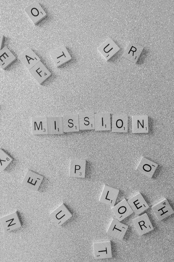 Scrabble tiles spelling 'MISSION' on a glittery surface, a symbolic and creative concept.